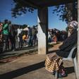 Informal traders and waste-pickers queue for food at a Soweto parking lot