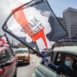 A women waves a flag from her car as part of a Warsaw protest against further tightening Poland's already restrictive abortion laws