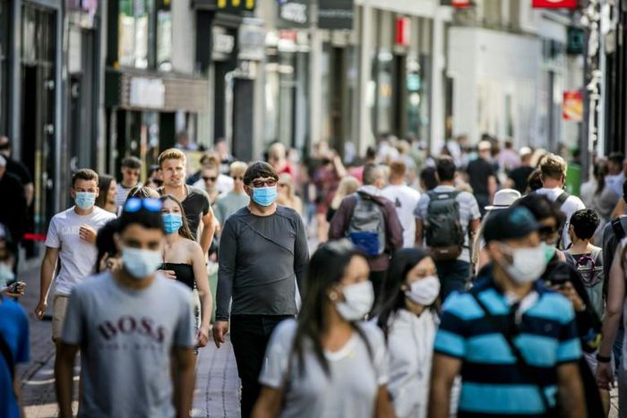 People, wearing a face mask, walk in the Kalverstraat, in Amsterdam on August 5, 2020, from when wearing a face mask is mandatory in five usually crowded places in the city of Amsterdam