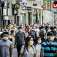 People, wearing a face mask, walk in the Kalverstraat, in Amsterdam on August 5, 2020, from when wearing a face mask is mandatory in five usually crowded places in the city of Amsterdam