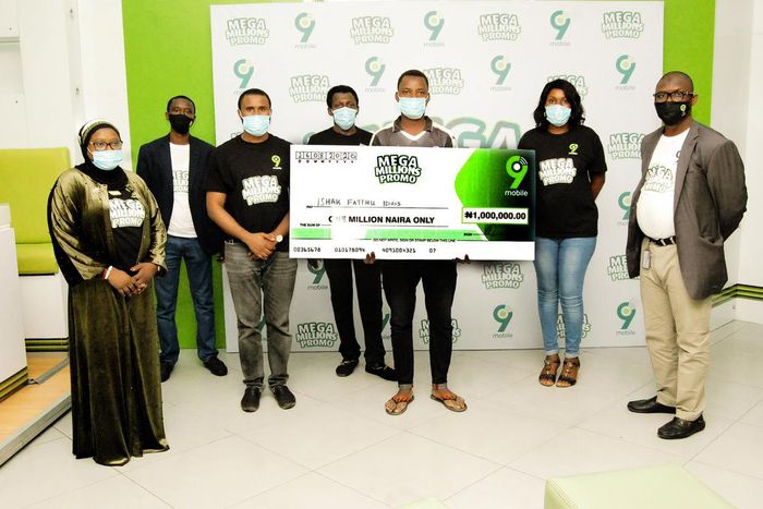 Ishak Fatihu Idris, N1million winner with 9mobile employees at the Experience center, Ado Bayero mall Kano in the ongoing 9mobile Mega Millions Promo prize presentation in Kano