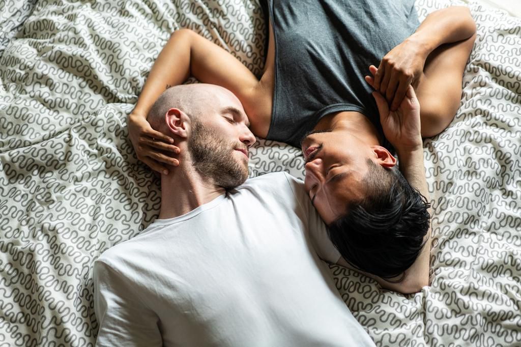 Directly above gay couple in bed