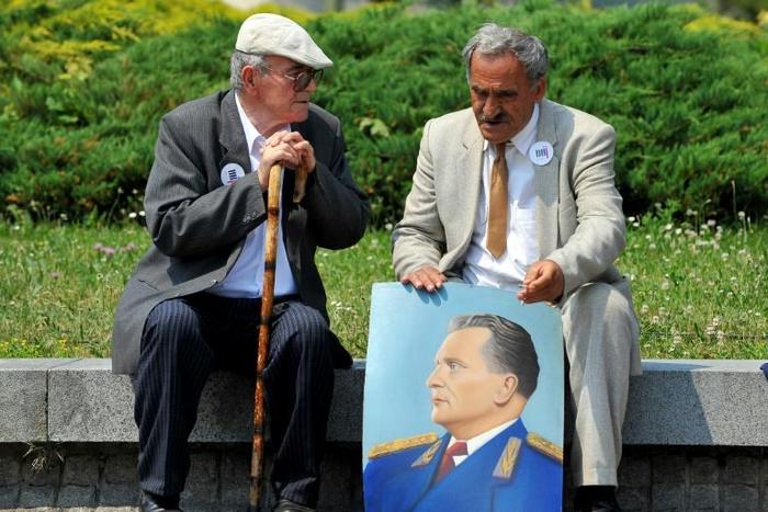 Two admirers reminisce about the late Yugoslav communist president Josip Broz Tito, commemorated in the portrait