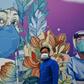 A man wearing a facemask walks in front of a mural at Leishenshan Hospital in Wuhan, China
