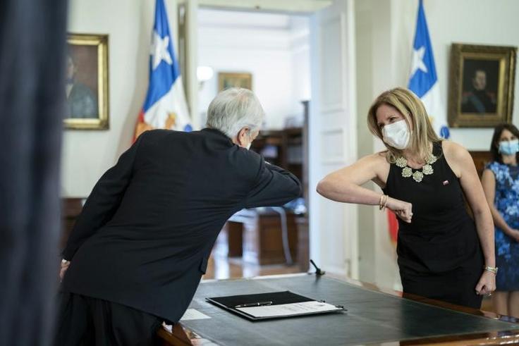 President Sebastian Pinera greets his new Minister for Women Macarena Santelices with an elbow bump at the presidential palace in Santiago, Chile