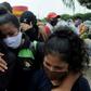 Relatives of a coronavirus victim who died at the start of the pandemic in Ecuador weep as they wait for the recently identified body to be returned to them
