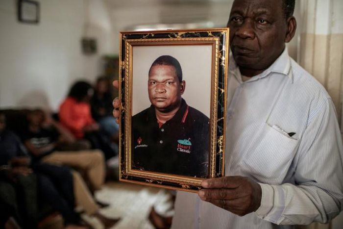 A spokesperson for bereaved relatives holds a portrait of Anastacio Matavele, an election monitor who was gunned down ahead of a key vote last October