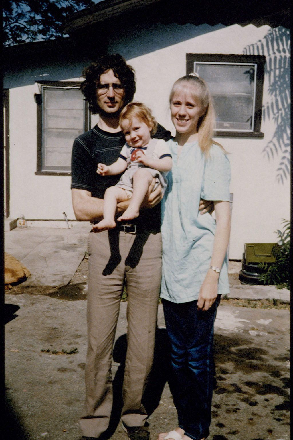 David Koresh, his wife Rachel, and their son Cyrus in front of their house.