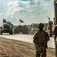US soldiers stand along a road across from Russian military armored personnel carriers near the village of Tannuriyah in Syria's northeastern Hasakah province on May 2, 2020