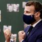 President Emmanuel Macron sporting a mask adorned with the red, white and blue of the French flag during a school visit.