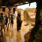 A Sudanese family inspects the damage to their home, after flash floods swept through the town of Umm Dawan Ban, southeast of the capital Khartoum, earlier this week