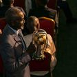 Stephen Tataw carries the trophy of the African Championship of Nations (CHAN) to the stage during the draw ceremony in Yaounde in February