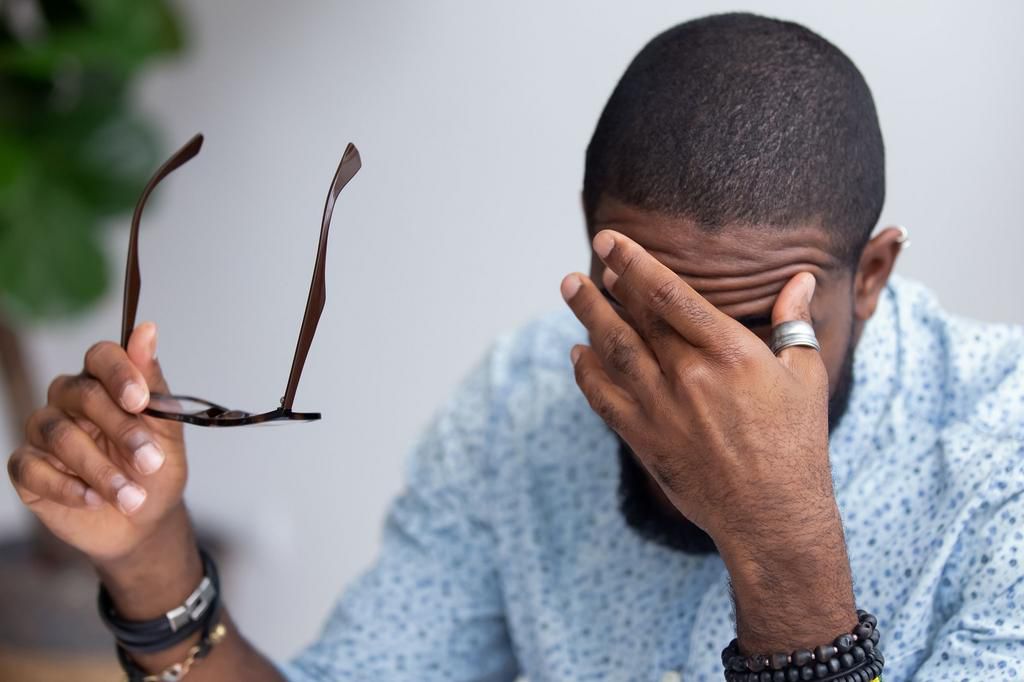 employee taking off glasses touching massaging eyes