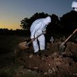 Workers wear protective clothing to bury a COVID-19 victim at the Sao Franciso Xavier cemetery in Rio de Janeiro, Brazil on May 29, 2020