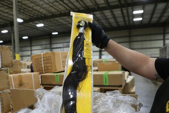 A US Customs and Border Protection officer at the Port of New York/Newark inspects a shipment of hair pieces and accessories from China suspected to have been made with forced or prison labor