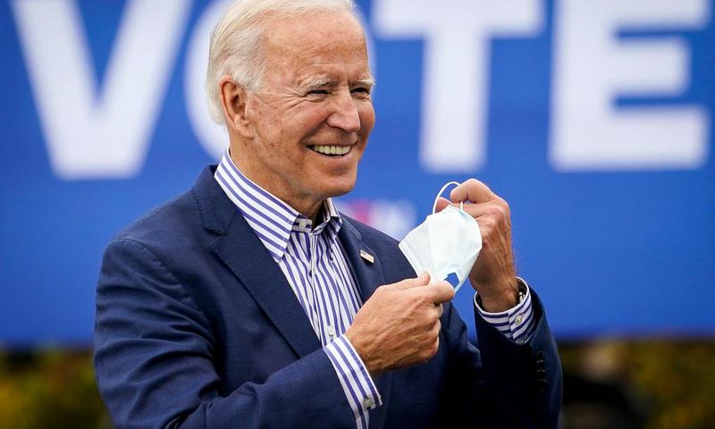 Democratic presidential nominee Joe Biden takes off his face mask to speak during a drive-in campaign rally at Bucks County Community College on October 24, 2020 in Bristol, Pennsylvania.