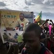 Supporters of the junta, which calls itself the CNSP (National Committee for the Salvation of the People), walk past a banner depicting its leader Assimi Goita in a rally in Bamako on Wednesday