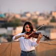 Fadia Khalil, a 22-year-old member of  the Iraqi National Symphony Orchestra, plays violin on the roof of her house in Baghdad