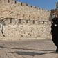 A priest, wearing a protective mask amid the Covid-19 pandemic, walks along the walls of Jerusalem's Old City on September 12, 2020