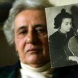 Holocaust survivor Anita Lasker-Wallfisch, pictured here in 2005, holds up a portrait of herself playing the cello in Berlin before World War II