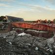 A railroad boxcar filled with ammonium nitrate lays on its side near to the remains of the fertilizer plant that exploded on April 18, 2013 in West, Texas