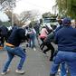 Protesters run from a stun grenade fired by police outside the Zimbabwean Embassy in South Africa's Pretoria