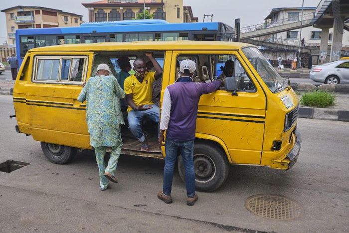 A Lagos bus driver places the mask below his nose as he 'shadows' passengers (Pulse)