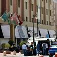 Mask-clad guests depart a hotel in the Saudi capital Riyadh, where hotels have been used to quarantine people to combat the spread of COVID-19