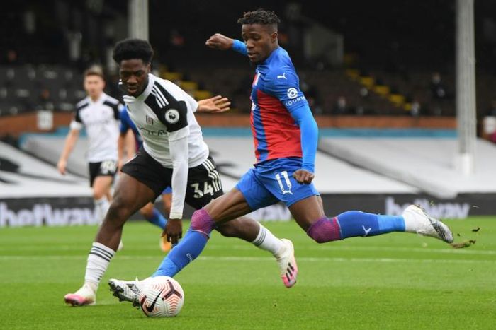 Fulham defender Ola Aina fails to prevent Crystal Palace winger Wilfried Zaha (R) unleashing a shot