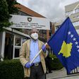 A man holds a Kosovo flag in a show of support for ousted leftist prime minister left-wing leader Albin Kurti