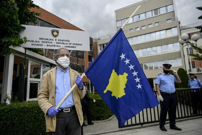 A man holds a Kosovo flag in a show of support for ousted leftist prime minister left-wing leader Albin Kurti