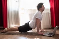 Young man working out, yoga, pilates, fitness training, exercises for spine