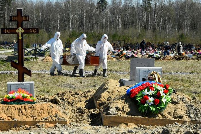 Cemetery workers in protective gear bury a coronavirus victim at a cemetery on the outskirts of Saint Petersburg. Russia has reported a remarkably low death toll but critics have cast doubt on the numbers