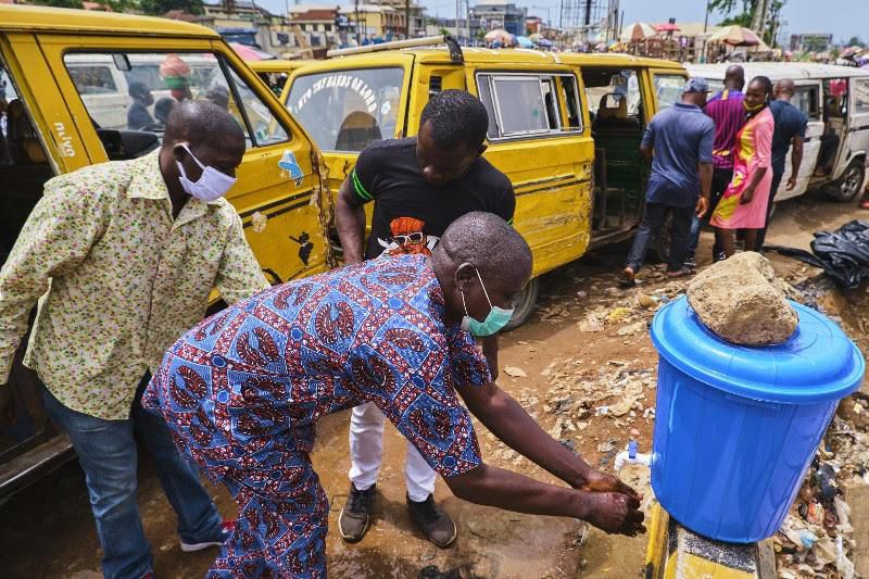 Commuters wash hands preparatory to boarding the bus in Lagos (Pulse)