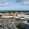 An aerial shot taken in April 2020 shows people waiting while adhering to social distancing in a parking lot before entering a supermarket in Grand Baie, Mauritius; the country has declared wary victory over the coronavirus