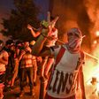 A Lebanese protester flashes the victory sign amid clashes with security forces in the centre of Beirut on Tuesday night
