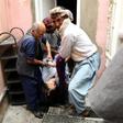 Men carry the dead body of a woman following a suicide attack on a maternity hospital in Kabul