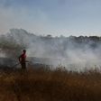An Israeli firefighter extinguishes a fire close to the Gaza Strip caused by an incendiary balloon