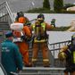Emergency personnel wearing protective gear spray disinfectant on colleagues at the site of a fire linked to ventilators at the Saint George hospital in Saint Petersburg on May 12, 2020