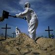 Members of the Rio de Paz NGO dig mock graves on Copacabana Beach on June 11
