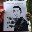 A woman holds a poster featuring an image of Ivan Safronov and the words "Journalism is not a crime"