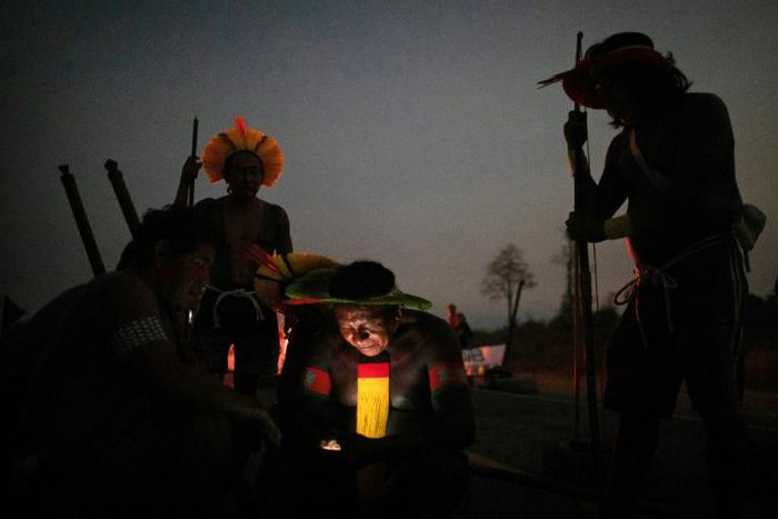 Members of the Kayapo Mekranoti ethnic group check their cell phones during a roadblock outside Novo Progresso, Para state