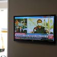 A funeral home worker in Curitiba watches the live news as President Jair Bolsonaro announces his positive COVID-19 test result