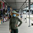 A woman wearing a face mask walks along the Tuan Chau harbour in Ha Long Bay, Vietnam