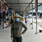 A woman wearing a face mask walks along the Tuan Chau harbour in Ha Long Bay, Vietnam