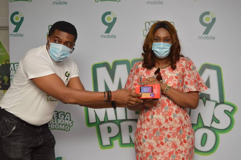 Chukwunonso Obi, 9mobile South-South Retail Sales Manager presenting Egondu Njoku with her smartphone prize at the ongoing 9mobile Mega Millions Promo prize presentation in Port Harcourt