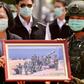 Taiwan President Tsai Ing-wen receives a framed photograph from a masked soldier during the COVID-19 coronavirus pandemic during a visit to a military base in Tainan on April 9, 2020