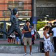 Football fans take pictures next to the statue of Portugal legend Eusebio outside Benfica's Estadio da Luz, which will host the Champions League final on August 23