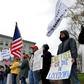 Hundreds of New Hampshire residents rallied outside the statehouse in Concord on April 18 to urge a quick end to the northeastern state's virus-related stay-at-home rule