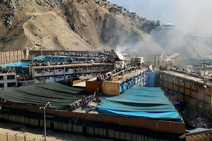 Smoke rises from the Castro Castro prison as inmates torched matresses in protest